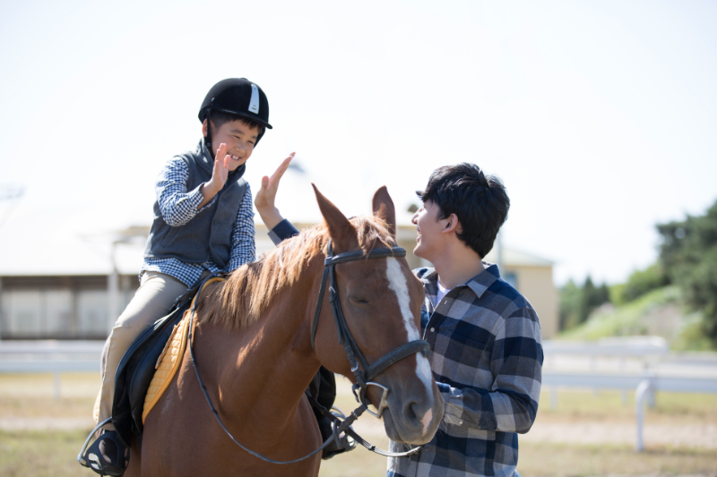 kid riding horse with his brother